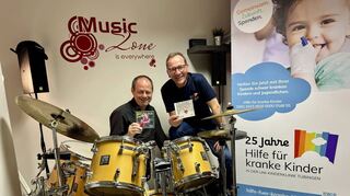 Harald Beibl (links) präsentiert die erste CD „Fröhliche Weihnachten“ aus dem Jahr 1999 und Thomas Hassel, Vorstandsvorsitzender von „Hilfe für kranke Kinder“, hält die neunte Scheibe in Händen.