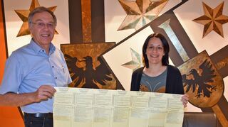 Der Stimmzettel für die Gemeinderatswahl in Bad Mergentheim am 9. Juni hat größere Ausmaße. Sieben Listen treten an. Gemeindewahlleiter Jürgen Friedrich und seine Stellvertreterin Melanie Baumann zeigen hier das aufwändige Werk in die Kamera.