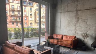 Sichtbeton, Ledersofas und große Glasflächen sorgen für eine coole und dennoch einladende Atmosphäre.