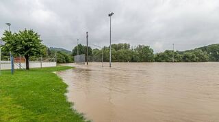 Der Sportplatz des VfR Gommersdorf steht nach dem Starkregen am Sonntag komplett unter Wasser. Nur noch die Flutlichtmasten sind zu erkennen.