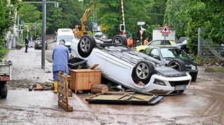 Mitgerissen von der Wucht des Wassers: Auf einer Straße in Rudersberg (Baden-Württemberg) liegt ein umgestürztes Auto.