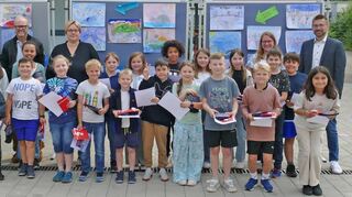 Die Preisträger des 71. Europäischen Wettbewerbs der Grundschule Süd Lauda mit Bürgermeister Dr. Lukas Braun (links), stellvertretender Schulleiter Dr. Rainer Gsell, Schulleiterin Natalie Ederer (Mitte), Betreuungslehrerin Fee Ungar und dem Filialleiter der Sparkasse Tauberfranken Thomas Fülling (rechts).