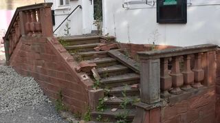 Die Sandsteintreppe am Eingang zum Gasthof zerfällt. Ein Teil der Balustrade ist bereits weggebrochen.