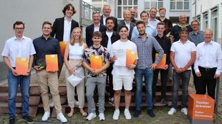 Die neuen Schreinergesellen mit Hermann Ruppert, Schulleiter der Gewerbeschule Tauberbischofsheim (obere Reihe, Zweiter von links), Michael Schneider, Vorstandsvorsitzender der Ihre Volksbank eG (obere Reihe, Dritter von links), Thomas Dürr, Vorsitzender der Prüfungskommission (obere Reihe, Fünfter von links), weiteren Vertretern der Ausbildungsbetriebe und Gewerbeschule sowie Jurymitgliedern.