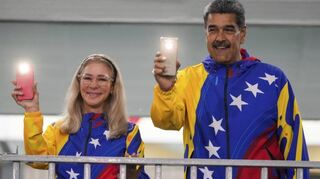 Präsident Nicolás Maduro und seine Frau Cilia Flores nach der Stimmabgabe im Flaggen-Dress mit eingeschalteten Handy-Taschenlampen.