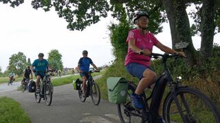 Am Nordende von Limbach, dem diesjährigen Startort, können die Drei-Länder-Radfahrer dank polizeilicher Begleitung die Scheringer Straße sicher überqueren, da der Verkehr für einige Minuten angehalten wird.