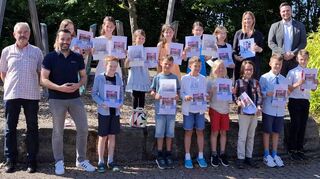 Kreisjugendreferent Dr. Michael Lippert (von links) und Bürgermeister Johannes Leibold freuen sich mit den stolzen Preisträgerinnen und Preisträgern der Freiherr-von-Zobel-Grundschule in Großrinderfeld: Neben den Orts- und Landespreisen haben vier Schülerinnen und Schüler dieser Grundschule auch Bundespreise erhalten. Ihnen gratulierten auch (hinten rechts) Dominic Dittmann von der Sparkasse Tauberfranken sowie Lehrerin Jenny Stolz.