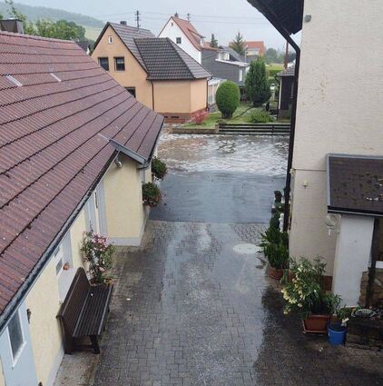 Bei dem heftigen Unwetter war auch Wasser in den Keller des ehemaligen Rathauses in Unterbalbach gelaufen (rechtes Bild). Im Ortskern von Unterbalbach sammelte sich infolge des Unwetters Wasser von den umliegenden Hängen. Auch Teile der Von-Ballo-Straße standen unter Wasser (linkes Bild).