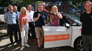 Das E-Auto an der Mobilitätszentrale in Lauda: Fabian Fluhrer, Siegfried Scheidel, Ursula Mühleck, Paul Gehrig, Christoph Schauder, Dr. Lukas Braun, Nina Warken und Thorsten Haas freuen sich darüber, dass das Sharing-Angebot der Mobilitätszentrale Lauda jetzt vollständig ist.