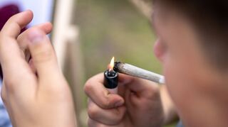 Ein junger Mann raucht auf einer Hanfmesse einen Joint. Die Fachmesse der Cannabis-Wirtschaft fand im Juni in Berlin statt.
