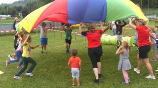 Bei der 35. Kinder-Olympiade waren viele verschiedene Spielstationen aufgebaut: Wenn alle mit anpacken, dann klappt es auch mit dem großen Tuch (Bild links). Nur mit der eigenen Puste durfte der Ball bewegt werden (Bild rechts).