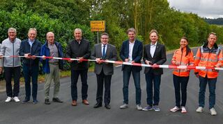 Fünf Kreisstraßen-Abschnitte haben in den Ferien eine neue Fahrbahndecke erhalten: In Großrinderfeld-Ilmspan hat Landrat Christoph Schauder (Bildmitte) gemeinsam mit den Fraktionsvorsitzenden des Kreistags sowie Vertretern des Straßenbauamtes und der zuständigen Baufirma stellvertretend für alle Maßnahmen den sanierten Streckenabschnitt der Kreisstraße K 2882 eröffnet.