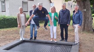 Spende des Lions Clubs Tauberbischofsheim übergeben: Das Bild zeigt Dr. Peter Flux beim Probespringen auf dem neuen Bodentrampolin mit (hintere Reihe, von links) Heike Theiler-Markert, Robert Barth, Bürgermeisterin Anette Schmidt, Michael Grethe und Roland Düll.