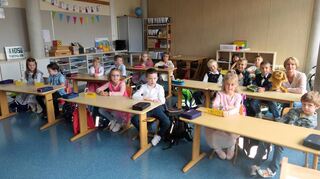 Die Mädchen und Jungen aus der 1a freuen sich in ihrem Klassenzimmer auf die Zeit in der Schule – mit Klassenlehrerin Agnes Spielmann und „Jojo“, dem „Klassentier“.