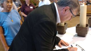 P. Joachim Seraphin MSF, der künftige Pfarrer der großen Kirchengemeinde, bei der Unterzeichnung der Gründungsvereinbarung der künftigen katholischen Pfarrgemeinde Lauda in Assamstadt.