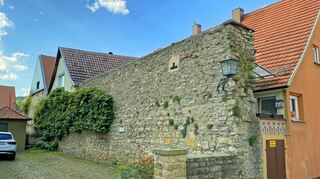 So stellt sich der Mauerabschnitt von der Schulstraße aus dar. Doch auf der Rückseite brechen Steine heraus, inden Fugen wachsen Pflanzen. Dringender Handlungsbedarf für die Stadt.