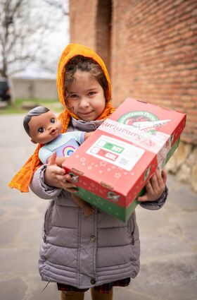 Kinder in Osteuropa beschenkt die Aktion „Weihnachten im Schuhkarton“. Das Bild zeigt ein glückliches Mädchen aus Georgien mit einer Puppe aus ihrem Schuhkarton. Auch in Bad Mergentheim und in der Region wird gesammelt.
