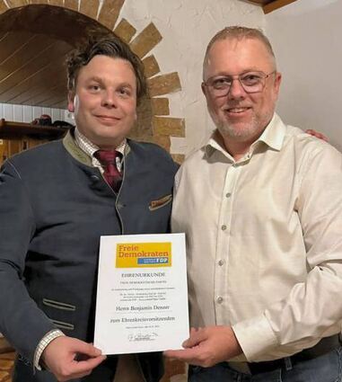 Jürgen Vossler überreicht Benjamin Denzer die Ernennungsurkunde zum Ehrenkreisvorsitzenden der FDP im Main-Tauber-Kreis.