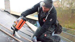 Mitarbeiter der Firma Rudorfer aus Tauberbischofsheim bringen derzeit die neuartigen Solardachplatten auf dem Dach in Höpfingen an.