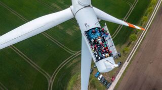 Hier besichtigen Lokalpolitiker und interessierte Bürger die Turbinen auf einer Windkraftanlage mit geöffnetem Dach. Neue Windräder in der Region sind in Planung.