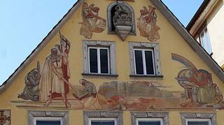 Musizierende Engel, Deutschordensritter, ein liegender Soldat und rechts daneben ein Gelehrter mit Globus: Die Malereien am Gänsmarkt Nr. 3 sind zum Teil schon deutlich verwittert.