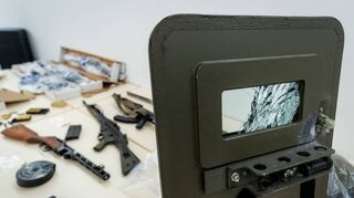 Ein beschädigtes ballistisches Schutzschild, das bei einer Wohnungsdurchsuchung in Bobstadt zum Einsatz kam, sowie ein Teil der Waffen, die in der Wohnung gefunden wurden.