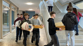 Die Schüler sind fleißig und tragen zahlreiche Unterrichtsmaterialien in den GTO-Neubau.
