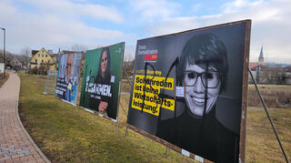 Mehrere Großplakate von CDU, Grünen und FDP wurden beschmiert. In schwarzer Schrift wurde über alle drei das Wort "Volksverrat" geschmiert.
