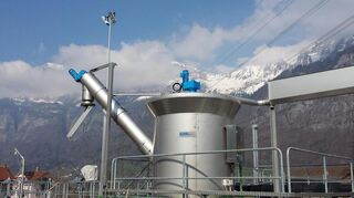 Eine Sachwaschanlager der Firma Kuhn vor Schweizer Bergen. Das Unternehmen stellt Maschien für Abwasserreinigungsanlagen her.
