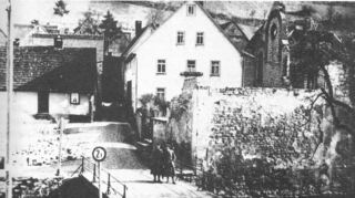 Auch die Königheimer Synagoge wurde beim Einmarsch der amerikanischen Truppen am Karsamstag 1945 durch Beschuss schwer beschädigt. Die Ruine prägte noch jahrelang das Ortsbild, bis die Sparkasse hier eine Filiale baute.