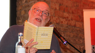 Mit hör- und sichtbarer Freude hat sich Sprecher Stefan Müller-Ruppert in die acht Bände vertieft, auf die er zum Welttag des Buches im Gastraum der Holzbronner derrHOF-Brauerei neugierig machte.