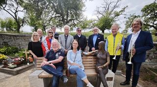 Brigitte und Thomas Hörner (sitzend) spendeten der Stadt Külsheim eine Bank mit der lebensecht wirkenden Plastik "Salome", geschaffen vom Künstler Leo Wirth (stehend Fünfter von links).