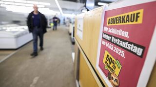 Einige Kunden laufen durch einen Laden, der inzwischen geschlossen hat.