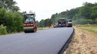 Die Mitarbeiter der Firma Trend-Bau tragen derzeit zwischen Erfeld und Gerichtstetten die Asphaltdecke auf.