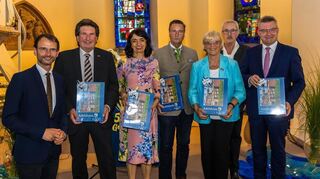 Bürgermeister Bernhardt, Minister Hauk, Landtagspräsidentin Muhterem Aras, Landrat Brötel und die weiteren Rednerinnen und Redner mit einem Geschenk: dem Adelsheim-Puzzle.