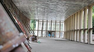 Die denkmalgeschützte Wandelhalle ist derzeit bis auf die tragende Struktur zurückgebaut – das Foto zeigt den freigelegten Innenraum während der Sanierungsarbeiten.