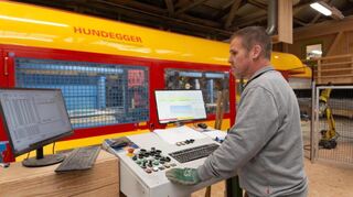Millimetergenaue Arbeit: Im Abbundzentrum der Firma Schumann werden Holzbalken auf einer CNC-gesteuerten Abbundanlage präzise zugeschnitten – Grundlage für hochwertige und passgenaue Holzkonstruktionen aus Igersheim.