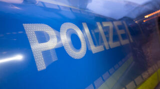 ILLUSTRATION - 30.11.2023, Baden-Württemberg, Stuttgart: Das Wort Polizei auf der Karosserie eines Polizeifahrzeugs (gestellte Szene, Wischeffekt durch Langzeitbelichtung). (zu dpa: «Mann wird bei Überfall lebensgefährlich verletzt»)