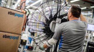 Ein Mitarbeiter des Elektromotoren- und Ventilatorenherstellers EBM-Papst arbeitet in der Produktion an einem Ventilator (Archivfoto).