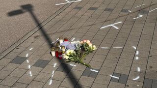 Markierungen mit Sprühfarben und Trauerbekundungen sind auf dem Parkplatz in Niedernhall zu sehen. Nach einem Streit soll ein 18-Jähriger einen zwölf Jahre alten Jungen mit dem Auto verfolgt, angefahren und tödlich verletzt haben. Der Heranwachsende sei nach der Tat am Donnerstagabend festgenommen worden, teilte die Polizei mit. Inzwischen wurde Haftbefehl wegen des Verdachts des Totschlags erlassen.