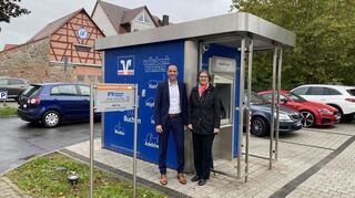 Um die Bewohner der Wohnung im Bankgebäude in Hettingen zu schützen, wird der Geldautomat auf den Parkplatz verlagert. Karin Fleischer und Dirk Gremminger von der Volksbank Franken sehen diese Lösung als eine wichtige Investition an.