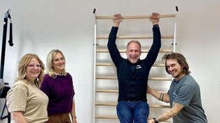Kreishandwerksmeister Timo Szabo testet die Sprossenwand in der Physiotherapiepraxis, „assistiert“ von Katja Gramlich, Angelika Gold und Stephan Popp.