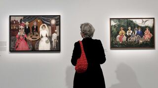 Blick in die Ausstellung: Eine Frau betrachtet Gemälde von Suzanne Duchamp.