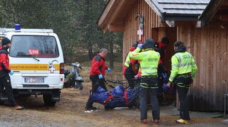 Zwei der Todesopfer werden zu einer Hütte getragen.