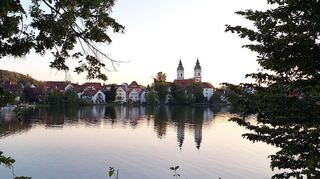 Der Stadtsee liegt malerisch mitten in der oberschwäbischen Kurstadt Bad Waldsee. Im Wasser spiegeln sich die Türme der Stiftkirche St. Peter.