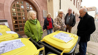 Volker Mohr von der Stadtverwaltung (rechts) hört sich die Beschwerden der protestierenden Leute an, die Gelbe Tonnen zum Rathaus gerollt hatten.