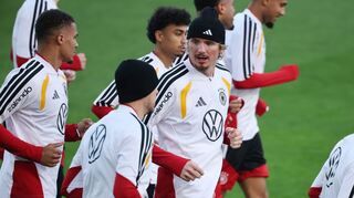 Thiaw (l.) und Woltemade (mit Mütze in der Mitte) laufen beim DFB-Training.