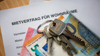 Ein Mietvertrag für Wohnräume liegt zusammen mit Wohnungsschlüsseln auf dem Tisch.