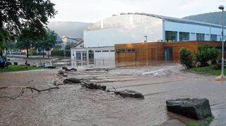 <p>Wassermassen, Geröll und Äste wurden von der Klinge aus auf die Sporthallen 1 und 2 gedrückt. Und die Schlammmassen erfassten auch die Breslauer Straße im Stadtteil Bestenheid. Hier wurde besonders das Anwesen Nummer 7 stark in Mitleidenschaft gezogen. Der komplette Garten und der Keller waren überflutet worden. Das Bild rechts zeigt die Aufräumarbeiten.</p>