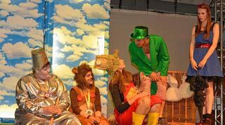 <p>Der Wächter der Smaragdstadt (Zweiter von rechts) verwehrt Dorothy (rechts) und den anderen drei "Helden" zuerst den Einlass in die Stadt. Später stellt sich heraus, dass er selbst der "große Zauberer von Oz" ist.</p>